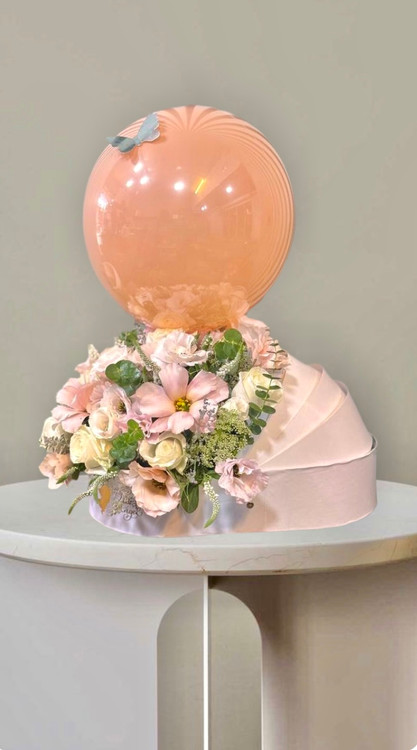 باکس گل نوزادی با گلهای رز و لیسیانتووس صورتی همراه با بادکنک هلیومی برای جشن تولد نوزاد