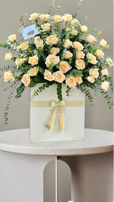 باکس گل شیک شامل ۴۰ شاخه رزکرم هلندی همراه با اکالیپتوس در جعبه سفید روبان دار