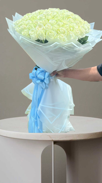دستهگل 100 شاخه رزسفید با کاغذ پیچی سفید وربان ابی سفارش از گلفروشی فلورسا در تهران