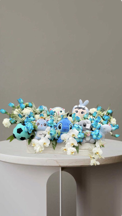 باکس تبریک تولد کودک با ترکیب گل های آبی وسفید و عروسک های فانتزی