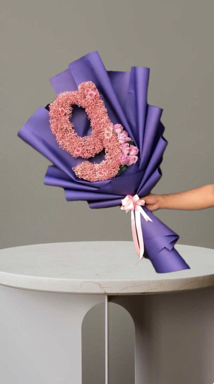 دسته گل حرف g صورتی با گل های صورتی و کاغذپیچی بنفش و ربان صورتی از گلفروشی فلورسا در تهران