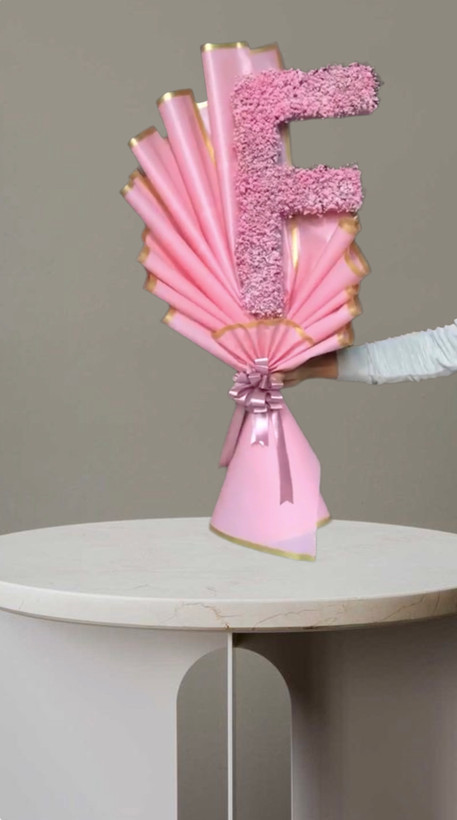 دسته گل تزیین شده به شکل حرف f با گلهای صورتی.دیزاین خاص با کاغذ و روبان صورتی شیک ارسال گل در تهران