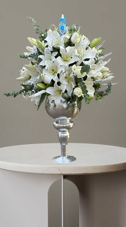 جام گل اورینتال سفید با ورونیکا و گانیا در جام نقره ای و تاپر ابی رنگ مناسب تبریک تولد نوزاد