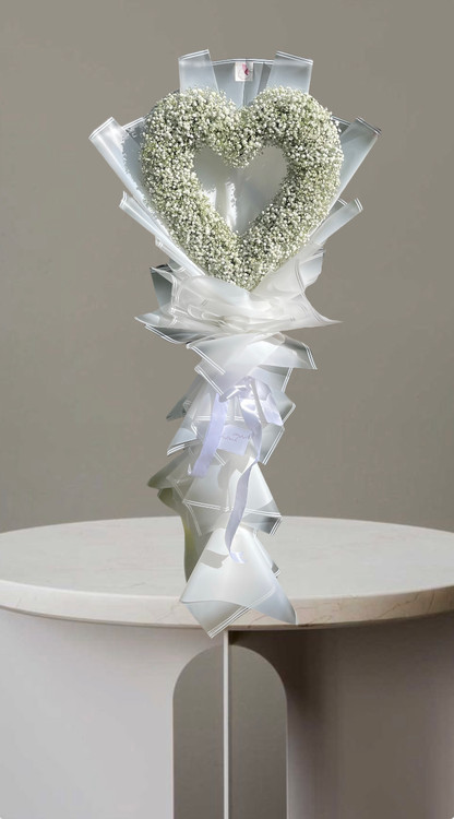 دسته گل قلبی سفید با ژیپسوفیلا و کاغذپیچی سفید شفاف و ربان سفید.گلفروشی فلورسا