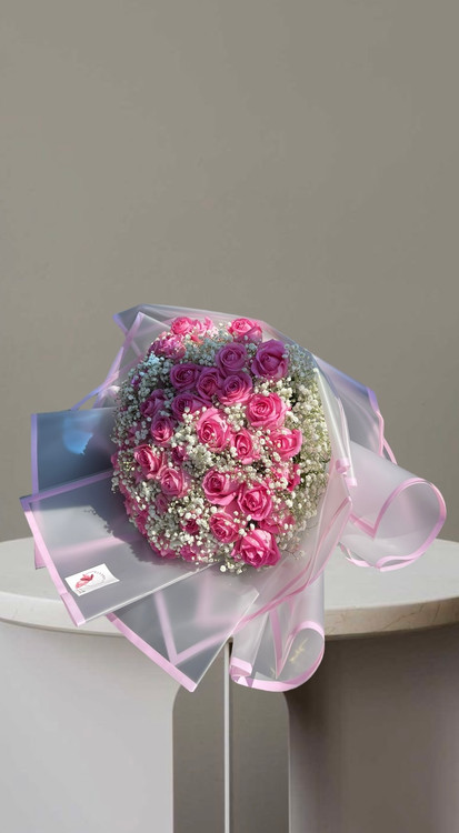 دسته گل سورپرایز رز صورتی با ژیپسوفیلا سفید،کاغذپیچی شفاف و روبان صورتی،مناسب هدیه و تبریک تولد،گلفروشی آنلاین فلورسا