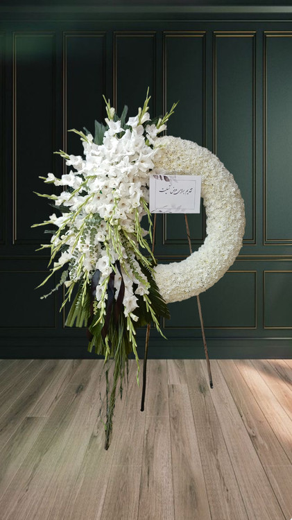 تاج گل تسلیت سفید با طراحی نیمدایرهای از گلهای گلایل و داوودی سفید مناسب مراسم ترحیم